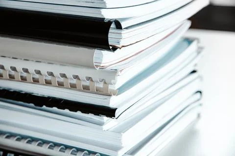 Stack of reports lies on a desk ready for review Stock Photos
