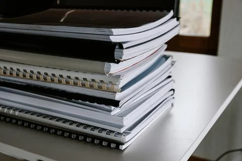 Stack of reports lies on a desk ready for review Stock Photos