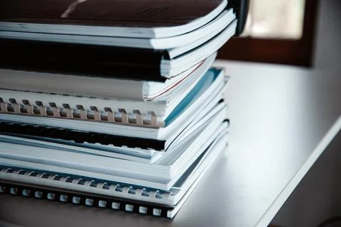 Stack of reports lies on a desk ready for review Stock Photos