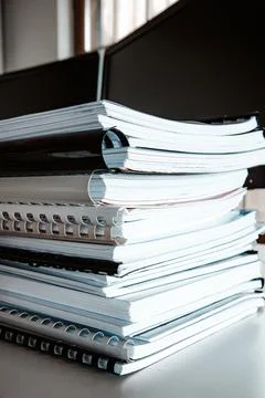Stack of reports lies on a desk ready for review Stock Photos
