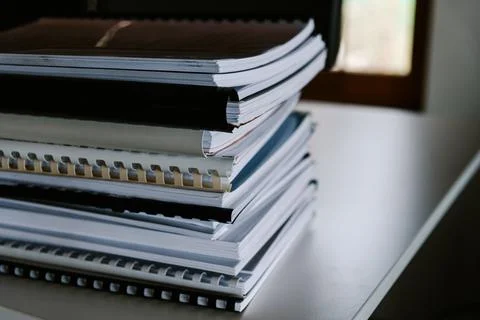 Stack of reports lies on a desk ready for review Stock Photos
