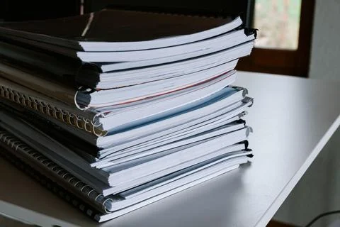 Stack of reports lies on a desk ready for review Stock Photos