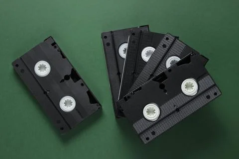 Stack of retro video cassettes on green background. Top view Stock Photos