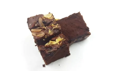 Stack of rich chocolate brownies with almond flakes moving footage Stock Footage 330939648