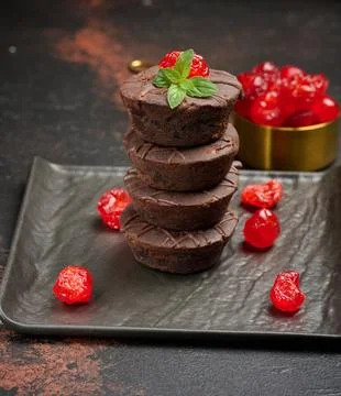 A stack of rich chocolate brownies topped with a glossy cherry and fresh mi.. Stock Illustration