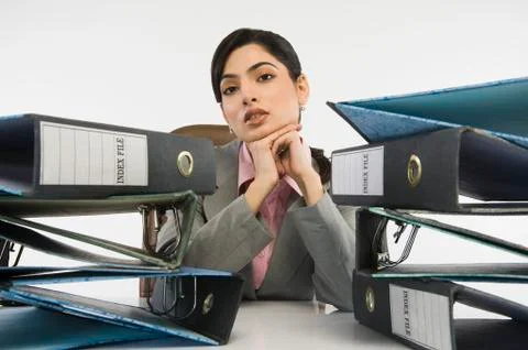 Stack of ring binders in front of a businesswoman 写真素材