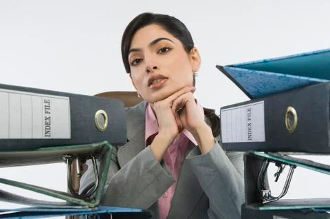 Stack of ring binders in front of a businesswoman Stock-Fotos