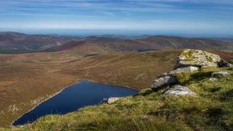 Stack of rocks on a hillside of Tonelagee Mountain with a view on lake Lough Stock Photos