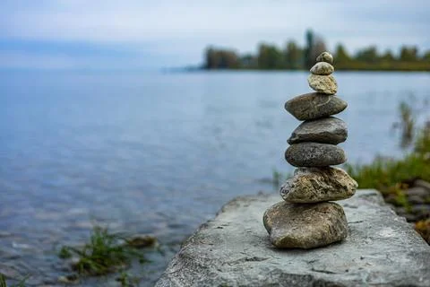 A stack of rocks on a rock by the water Stock Photos