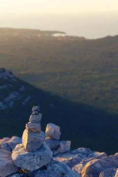 Stack of rocks on top of the mountain overlooking the bay on croatian island Stock Photos