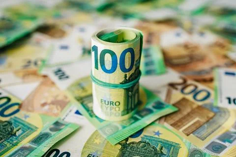 Stack of rolled 100 euro banknotes surrounded by various denominations of e.. 스톡 사진
