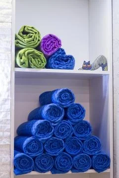 A stack of rolls of towels composed of a pyramid on a shelf in a yoga studio, Foto stock
