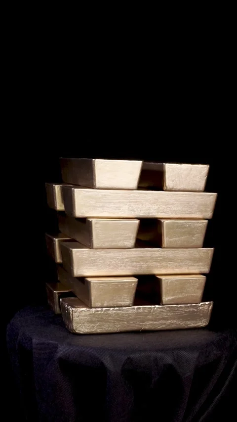 Stack of rotating gold bars on black background 動画素材 300266102