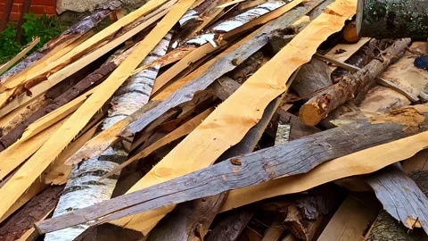 Stack of rough bark-covered slab wood cut from logs at rural sawmill yard Stock Footage 312718743