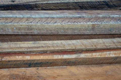 Stack of rough-sawn timber planks with natural grain and weathered texture Stock Photos