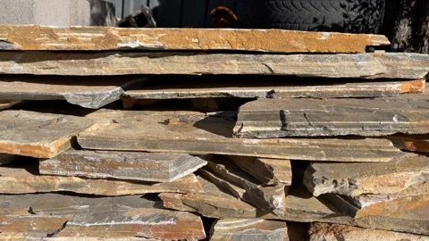 Stack of rough stone slabs with sunlight shadows, suitable for construction.. Stock Footage 328969121