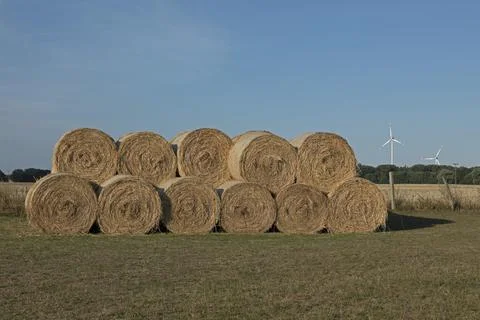 Stack of round bales straw wind turbines agriculture Allerstorf Marlow Stockfoto's