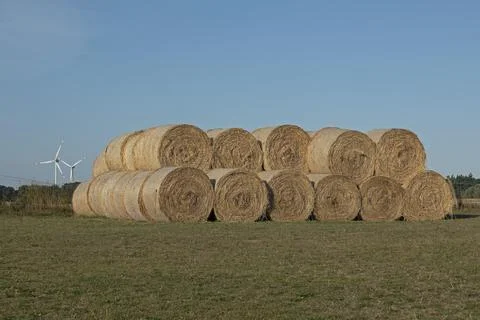 Stack of round bales straw wind turbines agriculture Allerstorf Marlow Foto stock