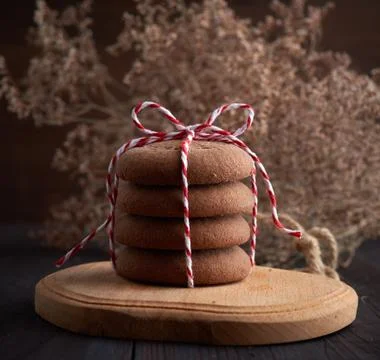Stack of round chocolate chip cookies tied with a rope on a brown board Stockfoto's