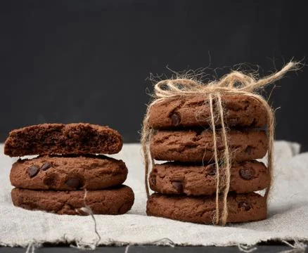 Stack of round chocolate chip cookies tied with a rope on a black board Foto stock