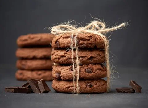Stack of round chocolate chip cookies tied with a rope on a black board Stock-Fotos