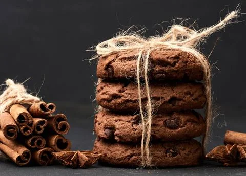 Stack of round chocolate chip cookies tied with a rope on a black board st... Stock-Fotos
