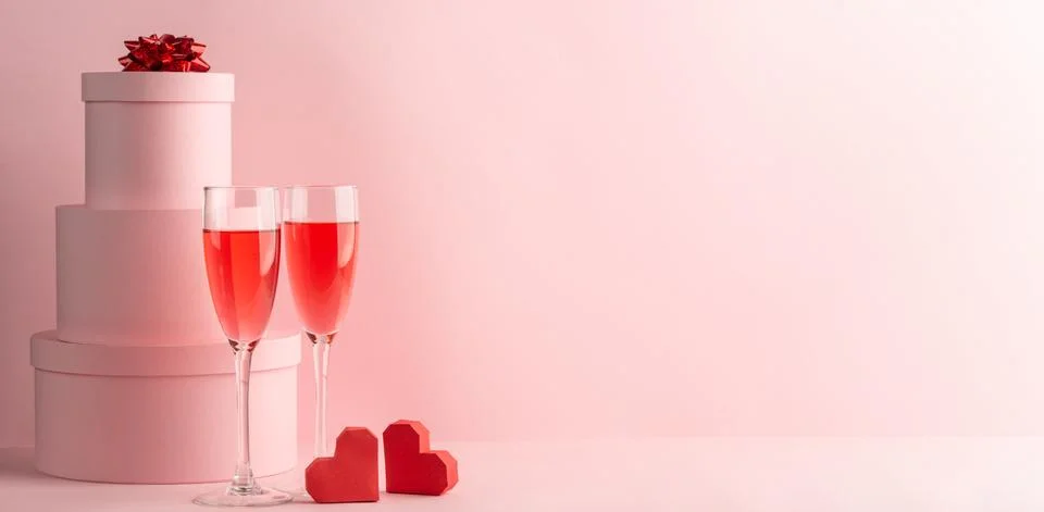 Stack of round gift boxes, glasses of red prosecco and two hearts Foto stock