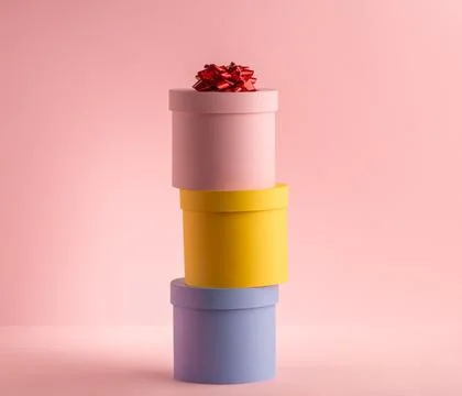 Stack of round gift boxes on pink background Foto stock