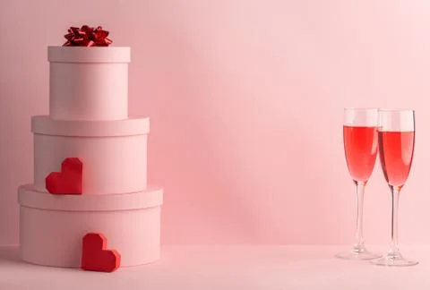 Stack of round gift boxes, red hearts and glasses of red wine for two Foto stock