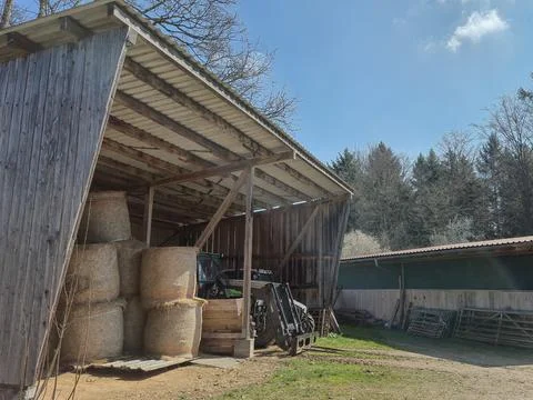 A stack of round hay bales stored inside a barn during the summer. The phot.. Stock-Fotos