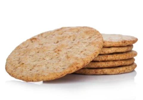 Stack of round organic crispy wheat  flatbread salty crackers on white Stockfoto's