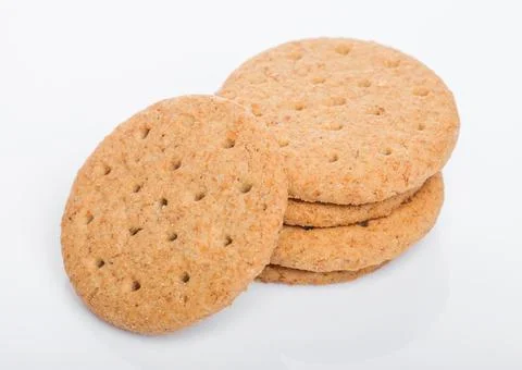 Stack of round organic crispy wheat and five grain salty crackers on white Stock-Fotos