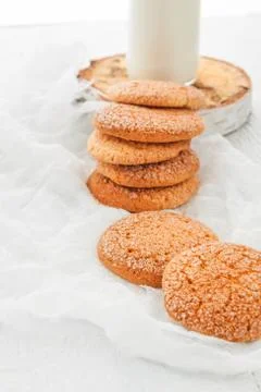 A stack of round shortbread cookies and a bottle of milk, on a white rustic.. Stockfoto's