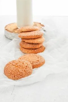 A stack of round shortbread cookies and a bottle of milk, on a white rustic.. Stock-Fotos