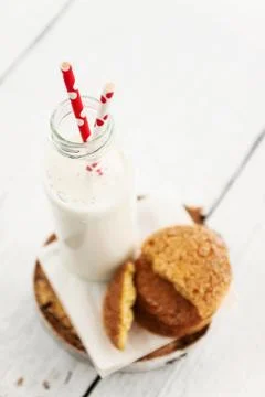 A stack of round shortbread cookies and a bottle of milk, on a white rustic.. Stock Photos