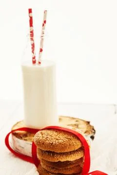 A stack of round shortbread cookies and a bottle of milk, on a white rustic b Stock Photos