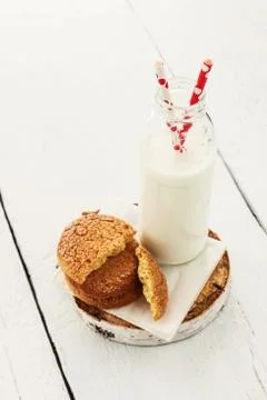 A stack of round shortbread cookies and a bottle of milk, on a white rustic b Stock-Fotos