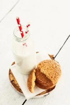 A stack of round shortbread cookies and a bottle of milk, on a w Stock-Fotos