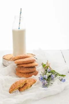 A stack of round shortbread cookies, a bottle of milk and a bouquet of blue.. Stock Photos