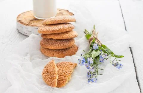 A stack of round shortbread cookies, a bottle of milk and a bouquet of blue.. Stock Photos
