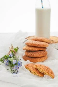 A stack of round shortbread cookies, a bottle of milk and a bouquet of blue.. Stock Photos