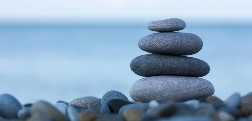 Stack of round smooth stones on a seashore Stock Photos