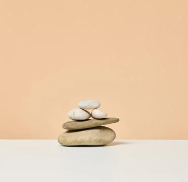 Stack of round stones on a beige background. Scene for demonstration of cosme Stockfoto's