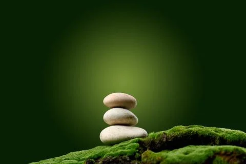 Stack of round stones on green moss, green background. Podium to showcase pro Stock-Fotos