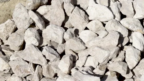 Stack of rubble stones outside, sunny day, and a man is taking some pieces. 库存影片 181966576
