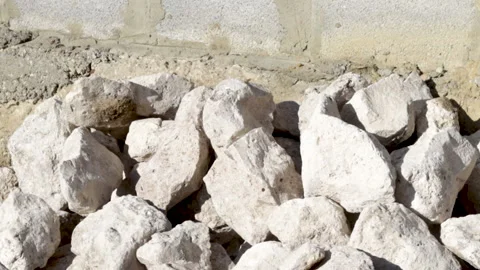 Stack of rubble stones outside, sunny day, and a man is taking some pieces. Video stock 181967116