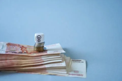 A stack of Russian bills with coins and a cube. The concept is an idea. Stock Photos