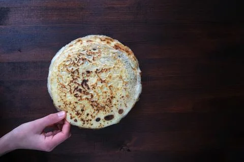 Stack of russian pancake blini on a dark rustic wooden background. Stock Photos