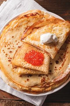 Stack of russian pancakes blini with red caviar, fresh sour cream Stock Photos