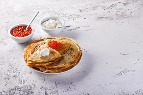 Stack of russian pancakes blini with red caviar, fresh sour cream Stock Photos